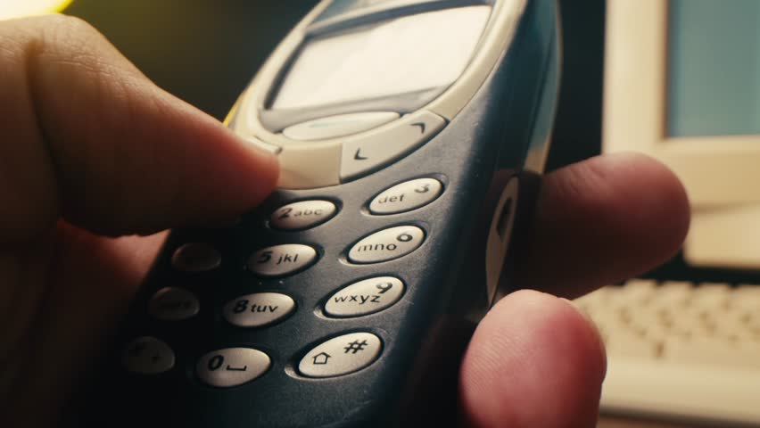 Man arm holding phone cellphone, vintage retro mobile phone, text message sms.