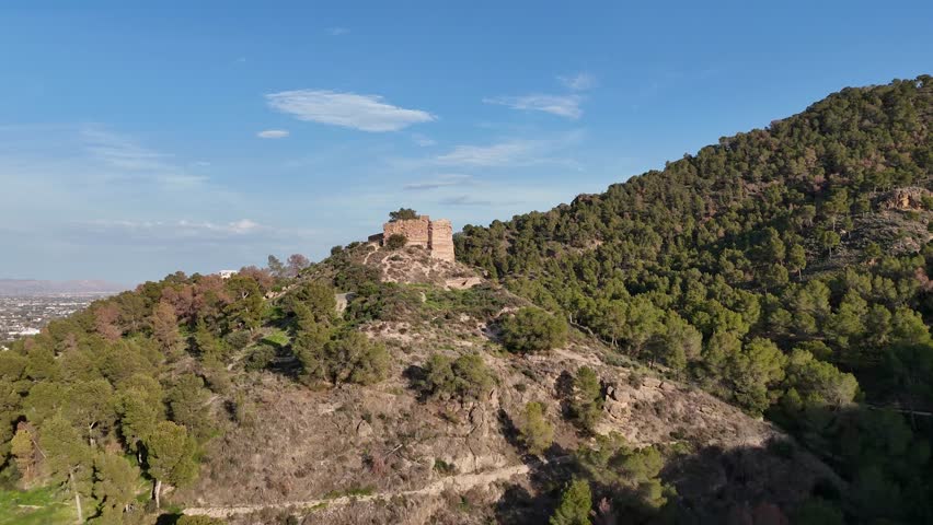 Aerial view of the remains of the medieval Castillo de la Luz on a hill in the El Valle natural park, Murcia, Spain