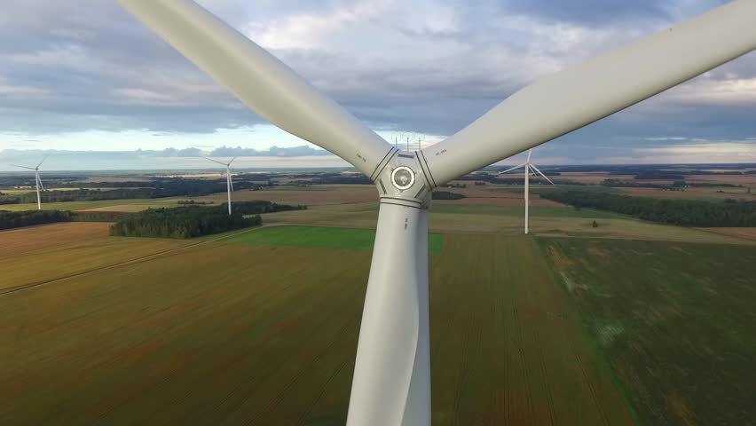 Windmills in Beautiful Nature, Landcape. Sustainable power. Aerial view of wind turbines. Alternative Eco Energy Wind Turbine in Beautiful Green Landscape at Sunset. Aerial drone view
