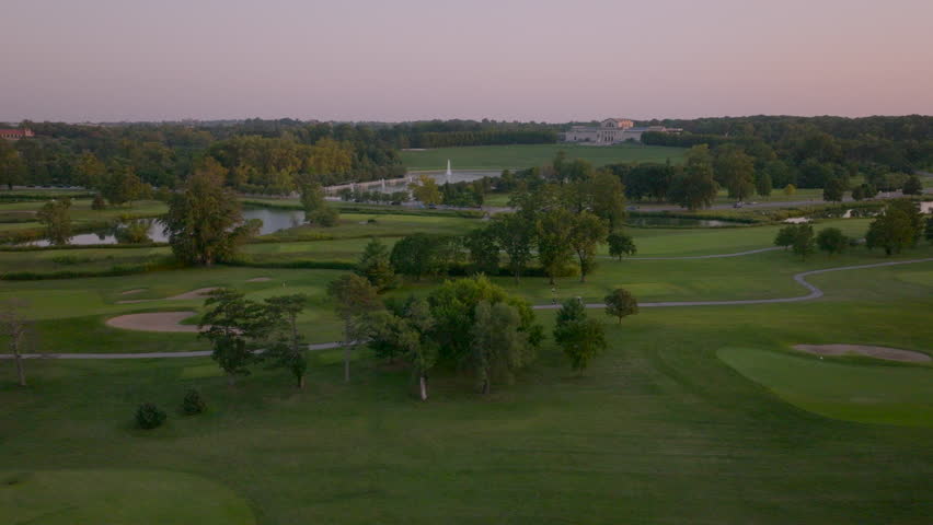 Aerial of Forest Park in St. Louis, Missouri with view of the Art Museum and the Grand Basin over golf course at sunset.