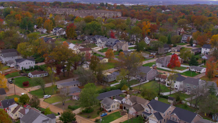 Aerial over Kirkwood neighborhood homes in St. Louis, Missouri in Autumn with a descent towards houses below.
