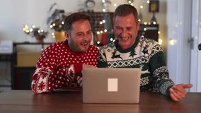 gay men couple celebrate christmas with laptop video call talking with family at home - Powered by Shutterstock - Get 15% off with code: PIKWIZARD15