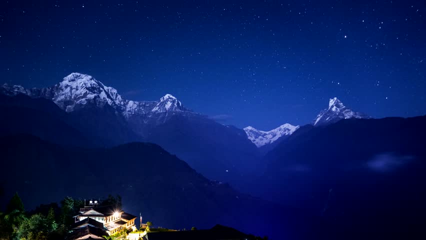 Night 4K time lapse of star trails (comet mode) above Annapurna South and Machapuchare, Ghandruk, Nepal