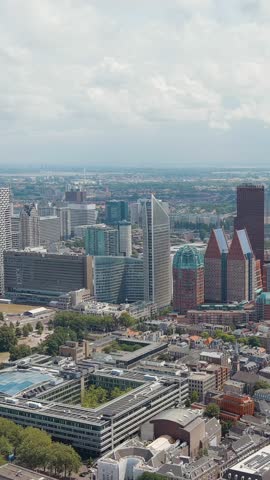 Vertical video. The Hague, Netherlands. Business center of The Hague. Large train station Den Haag Centraal. Cloudy weather. Summer day, Aerial View, Point of interest