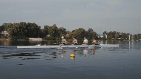 Rowing team training. Side view of 4 young caucasian male rowers resting, during a rowing practice, athlete sitting in a boat in the river Dnipro, calm water in autumn 4k footage - Powered by Shutterstock - Get 15% off with code: PIKWIZARD15