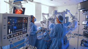 Approaching two medics working in the operating field of Da Vinci robotic machine. Doctor looks at the screen displaying minimal invasion surgery. - Powered by Shutterstock - Get 15% off with code: PIKWIZARD15