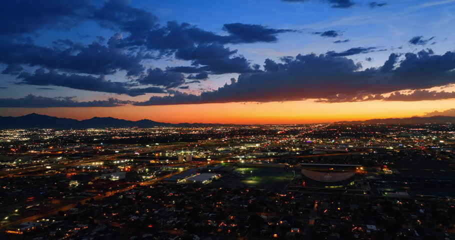 Lively cityscape of modern Phoenix, Arizona, the USA in the evening. Beautiful metropolis under orange-blue sky with clouds.