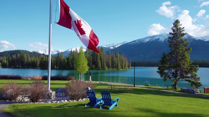 Canadian flag and mountains and trees. Jasper National Park summer landscape. Lac Beauvert Trail (Beauvert Lake).
