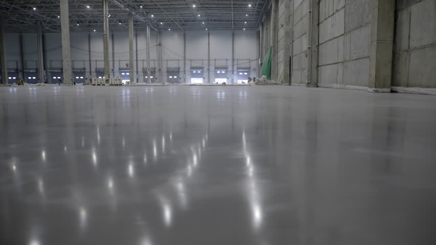 Expansive and Spacious Industrial Warehouse Featuring a Floor with Polished Reflection. Clip