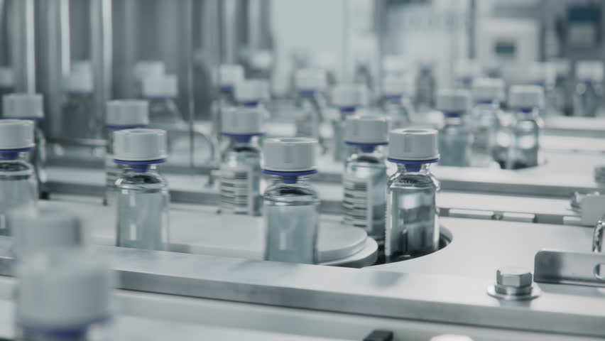 Medicine Manufacturing Process. Close-up of Medical Glass Vials with White Caps on Conveyor Line at Modern Pharmaceutical Factory. Medication Production Plant.