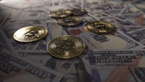 Close-Up of shiny bitcoin crypto currency coins on top of a 100 dollar bill. Rotating shot of Bitcoins digital cryptocurrency and dollar bill. Finance and investment concept - Powered by Shutterstock - Get 15% off with code: PIKWIZARD15