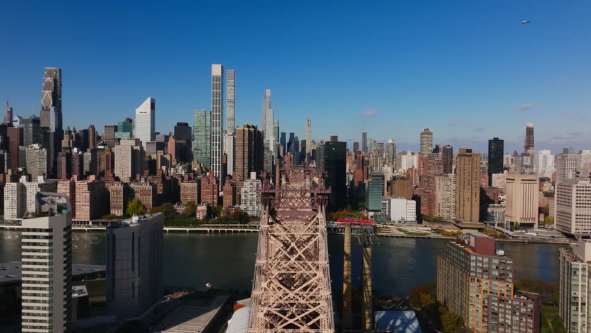 Aerial view above Queensboro Bridge and Roosevelt Island showcases East River flowing beneath, linking Manhattan and Queens in vibrant New York City