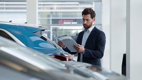 Caucasian man reading documents manager salesman consultant advisor specialist work clipboard car auto automobile dealer male businessman business seller agent checking papers guy electric transport - Powered by Shutterstock - Get 15% off with code: PIKWIZARD15
