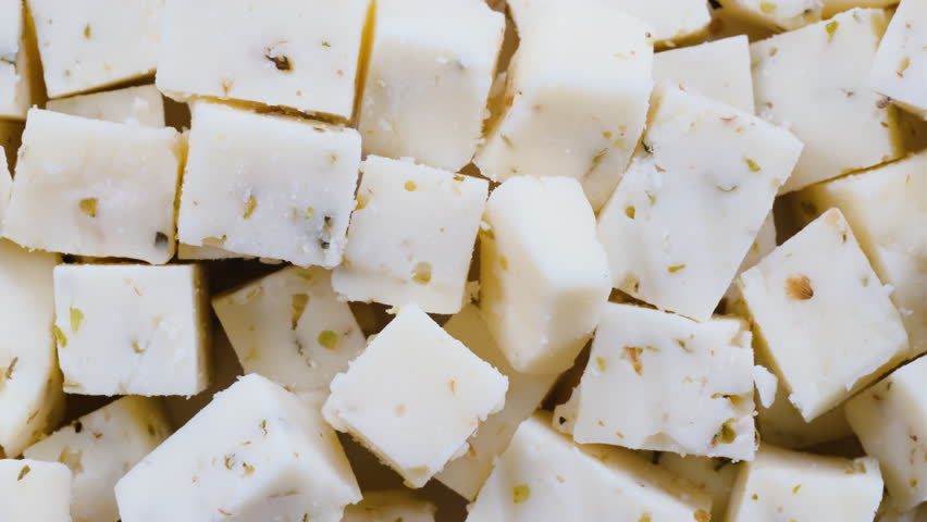 Top down view of flavorful herbed cheese blocks in close detail. Slider shot. Cooking , culinary, vegetarian food concepts. 4K 