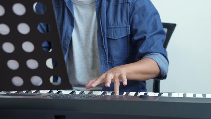 Young Musician Man Playing Piano And Practicing In Home Studio