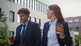 Cheerful business partners walking street holding coffee cups closeup. Smiling colleagues discussing work strolling modern urban area. Two coworkers enjoy friendly conversation in city environment. - Powered by Shutterstock - Get 15% off with code: PIKWIZARD15