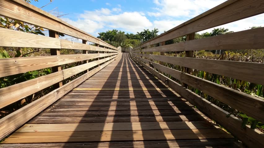 First person subjective point of view walking along the boardwalk in a sunny afternoon at Green Cay Wetlands Nature Preserve in Boynton Beach, Florida