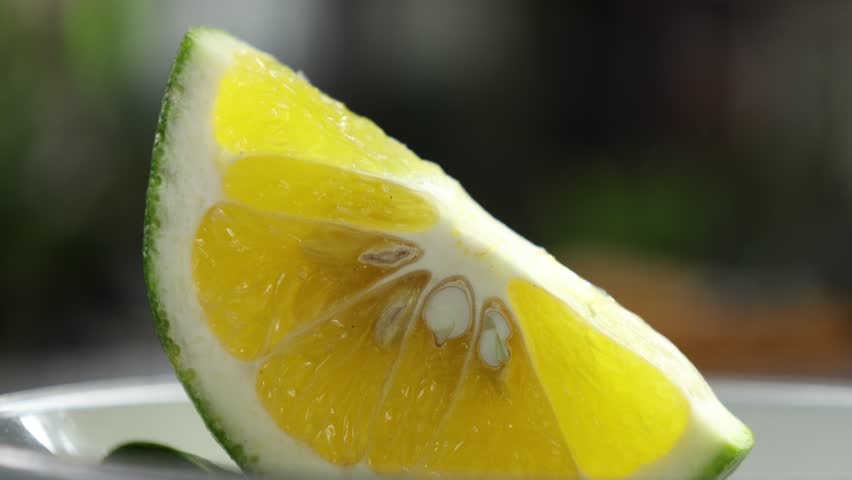Peeled mandarin orange segment on blurry background. Orange Slices on Wooden Table. 4K Fruit