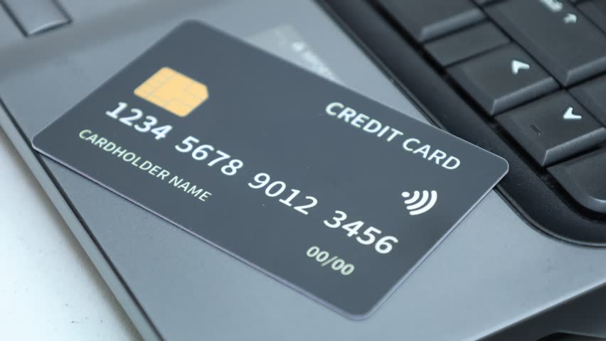 Makes a purchase on the Internet on the laptop with black credit card. Mobile payment ,online shopping concept. 