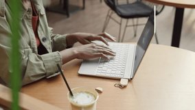 High angle view of unrecognizable African woman wearing casual clothes sitting at desk in modern office and inserting flash drive into computer - Powered by Shutterstock - Get 15% off with code: PIKWIZARD15