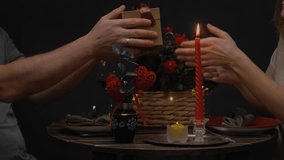 Valentines day celebration. Man in love giving a gift to his beloved during candlelit dinner for two. Romantic date of loving couple. - Powered by Shutterstock - Get 15% off with code: PIKWIZARD15