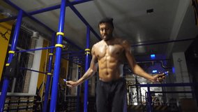 Strong african athlete with tattoos skipping with a jump rope at sport club. Young black sporty man doing cardio at fitness centre. Muscular afro american sportsman exercising at modern gym. Close up - Powered by Shutterstock - Get 15% off with code: PIKWIZARD15