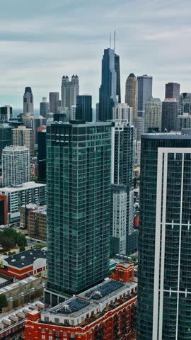 The skyline of Chicago displays a mix of modern architecture and historic buildings. Prominent towers rise against the sky, highlighting the city
