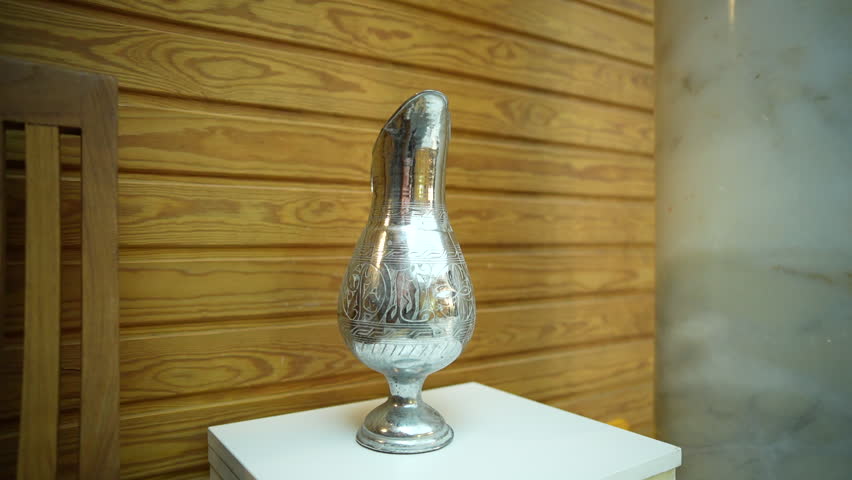 Close-up view of a silver vase adorned with intricate patterns, highlighting its craftsmanship and beauty.
