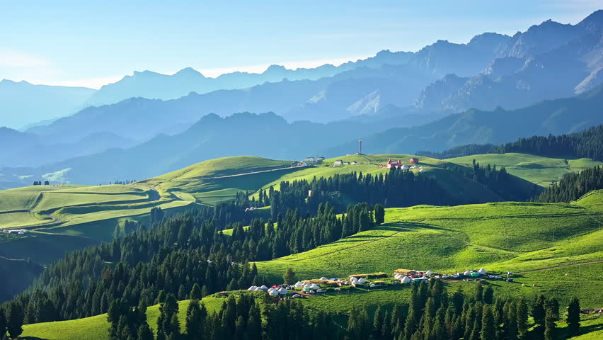Aerial view of green grassland and forest with mountain natural landscape in Xinjiang. Beautiful natural scenery in Jiangbulake Scenic Area, China.
