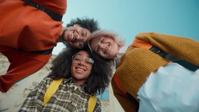 Bottom view friendly happy smiling faces portrait three students multiracial friends African American women girls female Caucasian boy man guy leaning foreheads smile in city sky university study - Powered by Shutterstock - Get 15% off with code: PIKWIZARD15