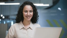 Confident businesswoman working on laptop computer sitting at workplace in business office. A smiling female employee is busy with a project, texting a client or chatting online. Close up. Front view - Powered by Shutterstock - Get 15% off with code: PIKWIZARD15
