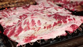 Delicious pork ribs grilling slowly on a barbecue fire - Powered by Shutterstock - Get 15% off with code: PIKWIZARD15