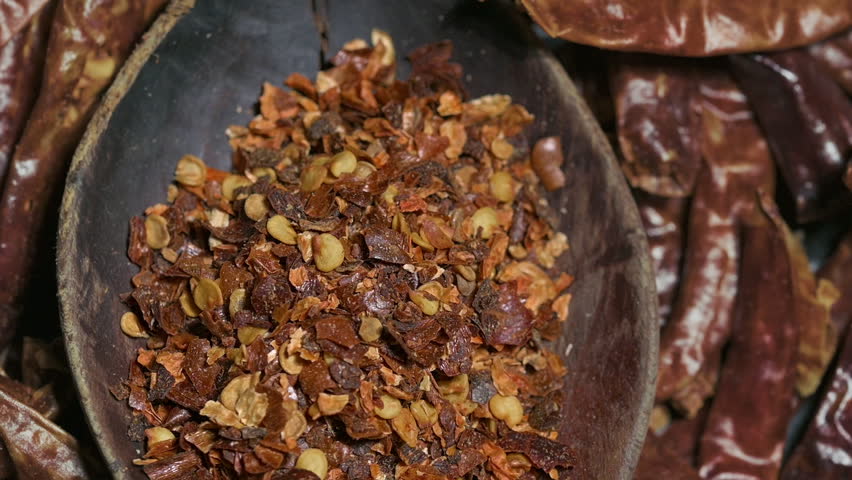 Red Chili Pepper Flakes in Wooden Board Top View