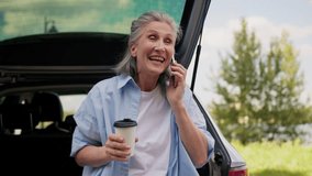 Happy smiling Caucasian retired business woman female senior mature automobile car driver businesswoman freelancer talking mobile phone speaking smartphone drinking coffee cup traveling outside nature - Powered by Shutterstock - Get 15% off with code: PIKWIZARD15