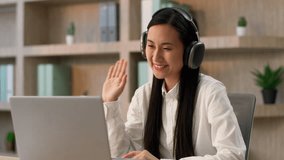 Smiling friendly Asian business woman Japanese Chinese girl ethnic female businesswoman Korean office worker operator in headphones headset talking online video call use laptop webcam computer indoor - Powered by Shutterstock - Get 15% off with code: PIKWIZARD15