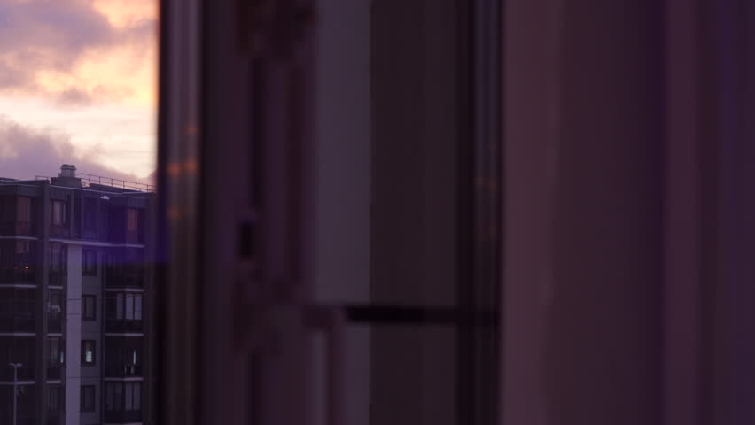 Red clouds lit by the morning sun over an apartment building, dawn in a residential area.