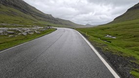 Moving forward on a rural two lane road running between mountains enveloped in fog, mist and low clouds. Located on the remote Scandinavian island of Eysturoy in the Faroe Islands. - Powered by Shutterstock - Get 15% off with code: PIKWIZARD15