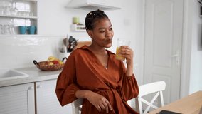 Young African American woman enjoying at her home and refreshing with juice - Powered by Shutterstock - Get 15% off with code: PIKWIZARD15