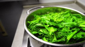 Boiling turnip greens with the intent of cooking them for the apulian dish "orecchiette con le cime di rape". Slow motion with bubbles coming from the water and smoke. - Powered by Shutterstock - Get 15% off with code: PIKWIZARD15