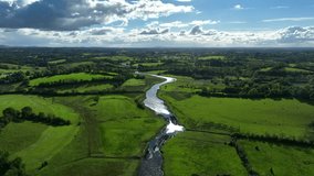 Finn River, County Monaghan, Ireland, September 2022. Drone pulls backwards in panoramic high angle overview of meandering water centered between pasture grasslands on sunny day. - Powered by Shutterstock - Get 15% off with code: PIKWIZARD15