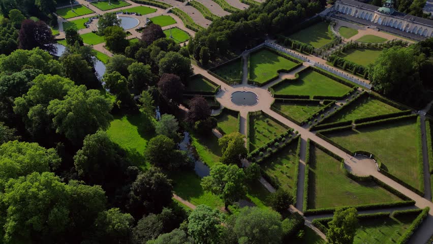 Sunny summer day Potsdam sanssouci Palace showing the beautiful green gardens and surrounding area. Majestic aerial view flight tilt up drone