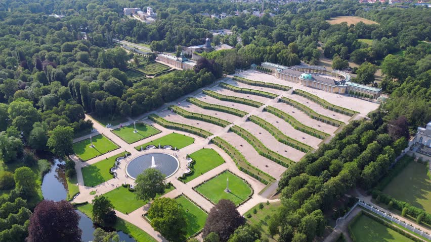 Sunny summer day Potsdam sanssouci Palace showing the beautiful green gardens and surrounding area. Stunning aerial view flight descending drone
