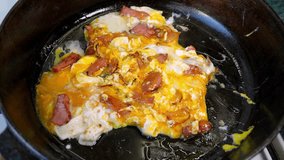 A chef skillfully prepares scrambled eggs with crispy bacon in a cast iron skillet. The dish sizzles as eggs cook and bacon releases its savory flavor. - Powered by Shutterstock - Get 15% off with code: PIKWIZARD15