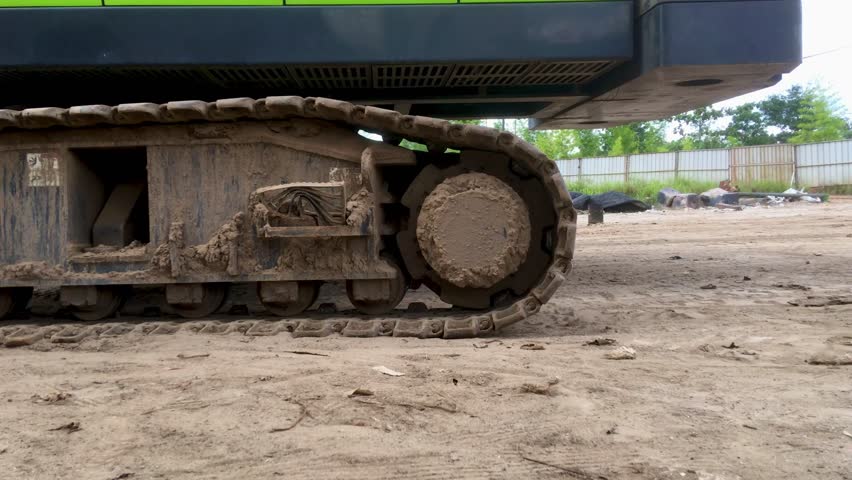 The lower wheel rotation of the crane. Tracking shot of a crawler bulldozer at work at a construction site. Heavy equipment that is running or creeping backwards