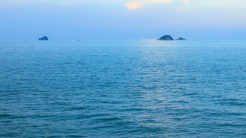 A landscape of sea, islands and sky at dusk, Thailand. 4K 3840x2160. Zoom out to wide shot. Time lapse. Can be establishing shot.