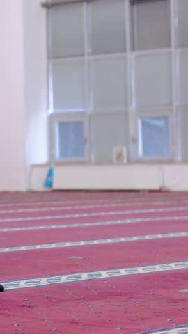 Muslim man praying with his forehead on the ground, young man who believes in islam prays to god in the masjid