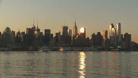 The mid-town Manhattan skyline is lit by sunlight just after sunrise in New York City.