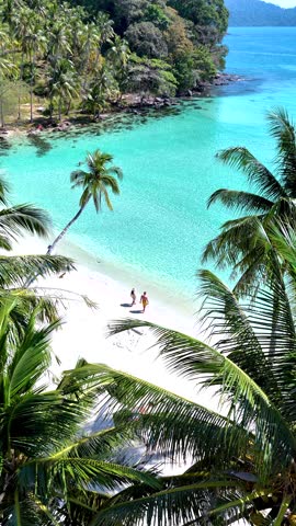 Experience the serene shores of Koh Kood Island where crystal-clear waters meet soft, sandy beaches. Relax under swaying palms while soaking in the sun, a couple on vacation in Thailand