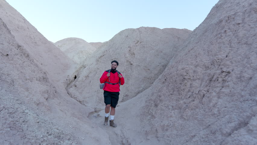 A curious tourist embarking on an adventurous hiking journey through the stunning and breathtaking desert scenery of Death Valley National Park during the warm and inviting fall season