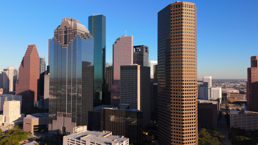 Cinematic aerial shot captures Houstons downtown skyline at sunset, highlighting modern architecture and the lively atmosphere of the bustling streets below, business and financial center of Texes